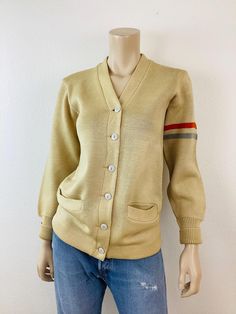 Vintage 1950s School Sweater v neck button front front pockets cream in color stripes at sleeve great vintage condition, minor wear appx size - S  18 pit-pit 26.5 length All sales are final Vintage Cardigan With Buttons For Work, Vintage Buttoned Cardigan For Work, Vintage Cardigan With Button Closure For Work, Vintage Button-up Cardigan For Work, Vintage Beige Cardigan For Work, Beige Vintage Cardigan For Work, Vintage Button-up Sweater For Work, Vintage Sweater With Button Closure For Work, Vintage Button Closure Cardigan For Work