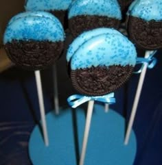 chocolate cake pops with blue frosting and sprinkles on top are arranged in a row