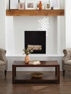 a living room with two chairs and a table in front of a fire place that is built into the wall