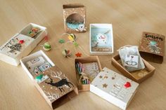 there are many small boxes on the table with christmas decorations and cards in them,