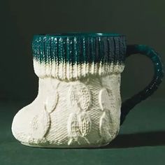 a green and white coffee cup sitting on top of a table