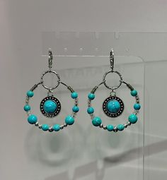 Show off your charm with these fun statement earrings, featuring lightweight  turquoise-colored Howlite beads and an enchanting turquoise pendant! The round pendant is the focal point of this pair, and is beautifully accented by the turquoise and silver components. Delicately handcrafted and designed, these unique and captivating earrings make a wonderful accent to any outfit! DETAILS: > Length (ear hook to bottom of earring): ~2 to 2.6in > Width (individual): ~1.25in > Earring Weight (both): ~.32 to .35oz > Nickel-free & hypoallergenic! > Beads: Howlite beads, silver-lined glass beads, glass seed beads, metal beads > Copper hoop, copper (or brass) leverback, 100% brass findings, 100% iron textured star > Jewelry findings are gently cleaned, applied with anti-tarnish shield, and polished V Turquoise Metal Jewelry With Dangling Beads, Turquoise Southwestern Hoop Earrings, Bohemian Turquoise Beaded Round Earrings, Bohemian Round Hypoallergenic Beaded Earrings, Bohemian Hypoallergenic Round Beaded Earrings, Bohemian Circle Jewelry With Dangling Beads, Bohemian Circular Jewelry With Dangling Beads, Bohemian Blue Hypoallergenic Jewelry, Turquoise Hoop Metal Jewelry