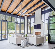 a living room filled with white furniture and large glass doors leading to an outside patio