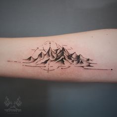 a mountain tattoo on the arm with dots and lines coming out of it's mountains