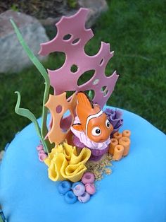 a blue cake with an orange clown fish on it's side and sea life in the middle