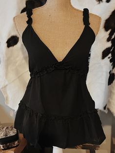 Cute black ruffle tank top! Fabric is on the thinner side & has adjustable straps. Summer Camisole With Built-in Bra And Ruffled Straps, Trendy Party Tank Top With Ruffles, Trendy Ruffled Tank Top For Party, Flirty Cami Tank Top With Ruffles, Flirty Camisole Top With Ruffles, Flirty Ruffled Camisole Tank Top, Flirty Ruffled Cami Tank Top, Fitted V-neck Tank Top With Ruffles, Flirty Spaghetti Strap Tank Top With Ruffles