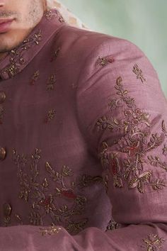 Dusty pink sherwani with floral embroidered thread work. Paired with cotton silk kurta, churidar pant.
Components:3
Pattern:Embroidered
Type of Work:Thread work
Neckline:Mandarin collar
Sleeve Length:Full sleeves
Fabric:Raw silk, Cotton silk
Color:Pink
Other Details:
Concealed placket
Note: Safa and necklace worn by the model is not for sale
Occasion:Wedding,Groom  - Aza Fashions Pink Sherwani, Thread Work, Full Sleeves, Wedding Groom, Embroidered Silk, Raw Silk, Mandarin Collar, Festival Wear, Aza Fashion