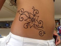 a woman's stomach with a tattoo design on the side of her belly,