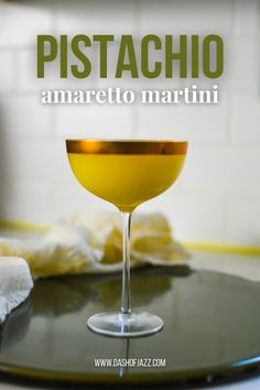 a glass filled with yellow liquid sitting on top of a table