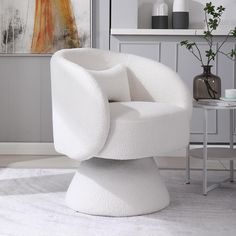 a white chair sitting on top of a rug in a living room next to a table