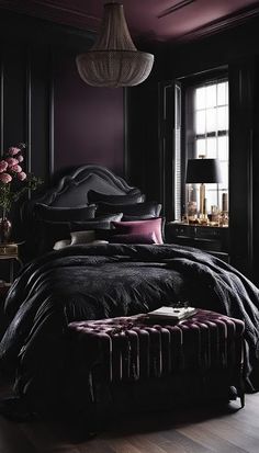 a bedroom with dark purple walls and black bedding, an upholstered headboard