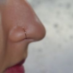 a close up of a person's nose with a nose ring in the middle