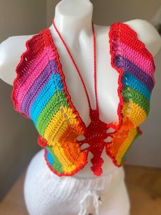 a white mannequin wearing a colorful crochet top