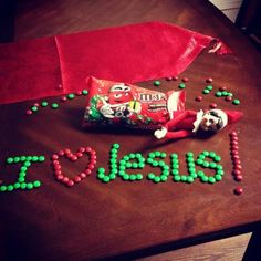 a candy bag with green and red candies next to it on top of a table