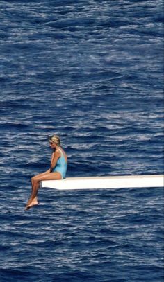 a woman sitting on top of a surfboard in the ocean