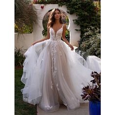 a woman in a wedding dress standing outside