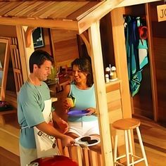 a man and woman cooking in a wooden cabin