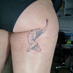 a woman's thigh with a tattoo of a man doing a kickbox pose