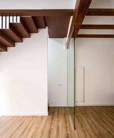 an empty room with wooden floors and white walls