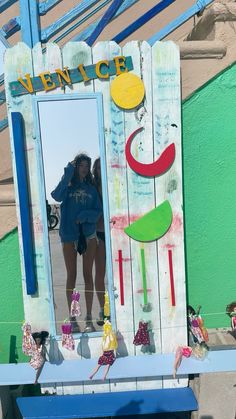 a woman standing in front of a mirror on top of a blue bench