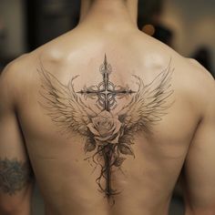 the back of a man with a cross and wings tattoo on his upper body, behind him is a rose