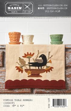 a kitchen towel with an image of a black cat on it and autumn leaves in the background