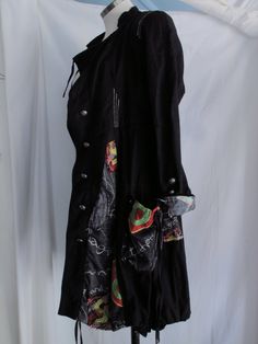 "Wearable art coat Loaded with detail. It's fashioned in an abstract 19th Century style. Features: * tailored bodice with flounced skirt * embroidery and patchwork throughout * metal crest buttons down the sleeves, down the front and on the waist in the back * drawstring neck, hem and pockets * metal gromets on the pockets Made by ANIMALE, Size Small. Measurements, laying flat: 15\" across shoulders 18\" underarm to underarm 17\" across waist 27.5\" across bottom hem 34\" length in front, 40\" l Black Cotton Outerwear For Alternative Fashion, Black Winter Festival Outerwear, Black Bohemian Cotton Outerwear, Black Bohemian Patchwork Outerwear, Bohemian Black Outerwear With Patchwork, Bohemian Black Patchwork Outerwear, Fitted Outerwear With Pockets For Festivals, Fitted Festival Outerwear With Pockets, Black Cotton Outerwear For Festivals