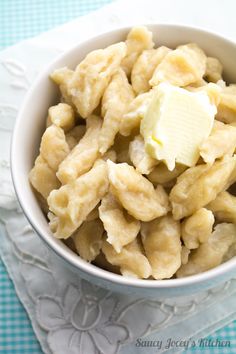 a bowl filled with macaroni and cheese on top of a blue checkered table cloth