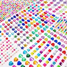 many different colored stickers are arranged on top of each other, including hearts and stars