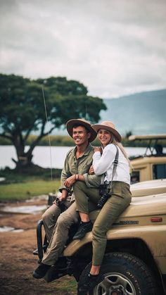 two people sitting on the back of a truck