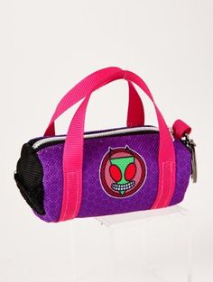 a purple and pink handbag with an alien face on the front, sitting on a clear acrylic stand