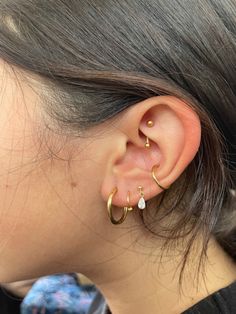 a close up of a person wearing an ear with two different types of piercings