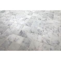 a white marble tile floor with grey grouting