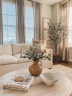 a living room filled with furniture and a coffee table in front of a large window