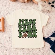 Football Birthday Shirt, Football First Birthday, First Birthday Shirt, Birthday Boy Shirt, First Birthday, Toddler Birthday Shirt  💗  Welcome to The WildflowerbyMiley Etsy Shop!  This listing is for the bodysuit, sweatshirt or t-shirt only. All other items that are shown in our photos such as shoes, hats, beanies, blankets etc. are for photo staging purposes and are NOT INCLUDED in the sale. DESCRIPTION:  This baby and children's unisex essential fits like a well-loved favorite. Super soft t-shirts, sweatshirts and baby bodysuits for your little lads and gals meant to showcase their big personalities. Its Excellent quality and vibrant print makes one fall in love with it over and over again.  This adorable piece is the perfect lightweight layer for casual wearing.  This product is hand p Fun Green T-shirt For Birthday, Green Fun Birthday T-shirt, Casual T-shirt With Number Print For First Birthday, Cotton Number Print T-shirt For Birthday, Cotton T-shirt With Number Print For Birthday, Green Cotton T-shirt For First Birthday, Green Graphic Print T-shirt For First Birthday, First Birthday Short Sleeve T-shirt With Text Print, First Birthday T-shirt With Text Print