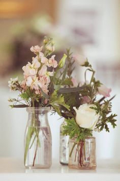 two vases filled with flowers on top of a table