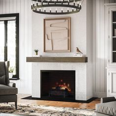 a living room with a fire place in the center and a painting on the wall