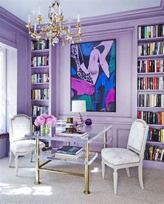 a living room filled with furniture and a chandelier above a glass top table