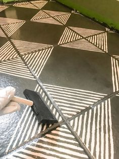 a person in white gloves cleaning a tiled floor