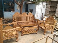 wooden furniture sitting on the ground in front of a tree