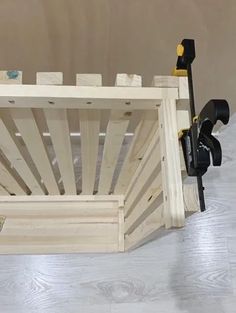 a wooden crate sitting on top of a hard wood floor next to a tool holder