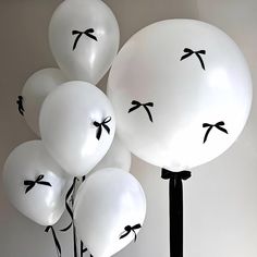 white balloons with black bows on them