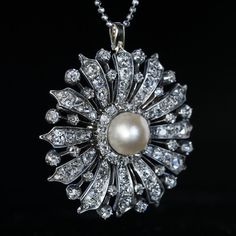 Circa 1870 A finely crafted in silver-topped gold (front - silver; back - gold) Victorian era brooch / pendant is designed as a stylized flowerhead, centered with a large (10 mm) natural saltwater pearl surrounded by chunky old cut diamonds (G-H-I color). Estimated total diamond weight is 8.20 carats. Diameter 43 mm (1 10/16 in.) Sold without chain Victorian White Gold Pendant Brooches, Elegant Yellow Gold Medallion Brooches, Victorian Hallmarked White Gold Brooch, Antique White Gold Brooches With Rose Cut Diamonds, Victorian Hallmarked White Gold Brooches, Elegant Medallion Brooch For Formal Occasions, Elegant Medallion Shaped Brooch Jewelry, Elegant Medallion Shaped Brooch, Elegant Flower Pendant Brooch Jewelry