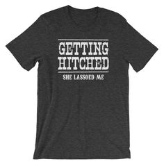 "Getting Hitched shirt - She Lassoed Me - Engagement couples gift tees - Country or southern wedding - Short-Sleeve Unisex T-Shirt Get matching shirts for him and her! Distressed print style! This t-shirt is everything you've dreamed of and more. It feels soft and lightweight, with the right amount of stretch. It's comfortable and flattering for both men and women. * 100% combed and ring-spun cotton (heather colors contain polyester) * Fabric weight: 4.2 oz (142 g/m2) * Shoulder-to-shoulder tapi Feminist Tshirt, Airplane Shirt, Getting Hitched, Couples Gift, Southern Wedding, Unisex Shirt, Funny Shirts, Types Of Shirts, Shirt Online