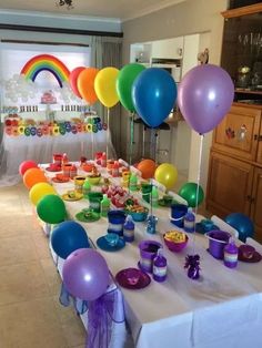 the table is set up with balloons and candy