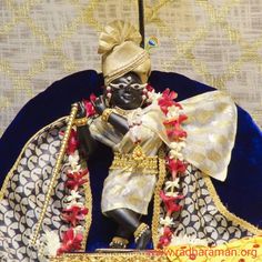 a figurine sitting on top of a blue plate covered in gold and red decorations