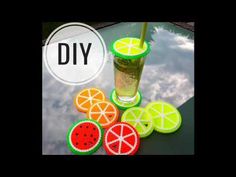 a glass filled with liquid sitting on top of a table next to sliced oranges and watermelon slices