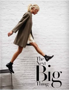 a woman in black boots is jumping on a white brick wall with the words'the next big thing '