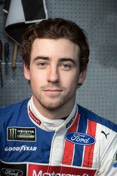 a man in a racing uniform posing for a photo