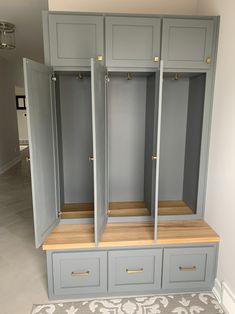 an empty room with some gray cabinets and drawers on the wall, in front of a carpeted floor